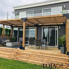 an outdoor patio with wooden steps leading up to the deck and seating area on top of it