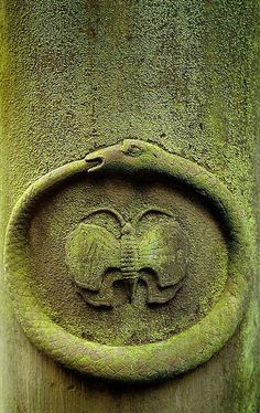 a close up of a stone carving on a pillar with two birds in the middle