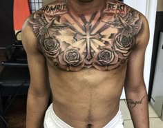 a man with a cross and roses tattoo on his chest