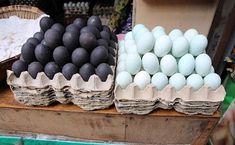 there are several eggs in baskets on the table and one is black, white or gray