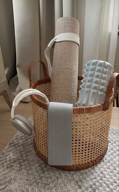 a wicker basket with headphones in it on a table next to a window