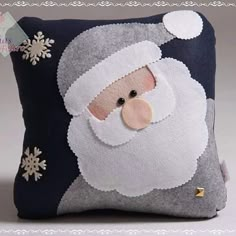 a christmas pillow with a santa clause on it's face and snowflakes