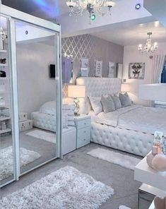 a white bedroom with mirrored walls and chandelier hanging from the ceiling, carpeted floor