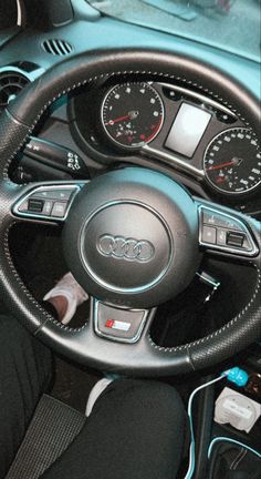 the interior of a car with steering wheel controls and dashboard gauges, including an automatic