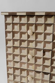 a chest of drawers made out of wood with geometric designs on the front and sides