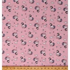 a pink fabric with unicorns and clouds on it, in front of a ruler