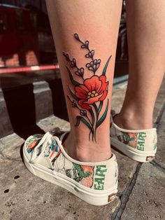 a woman's foot with a flower tattoo on it