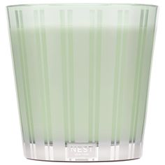 a green glass vase sitting on top of a white table