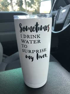 a white cup sitting on top of a car dashboard