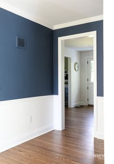 an empty room with hard wood floors and blue walls