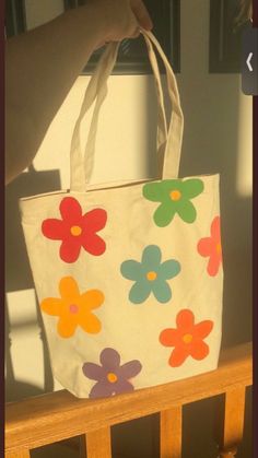 a person is holding a bag with flowers on it