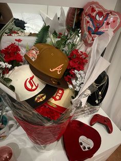 a bunch of hats sitting on top of a table next to flowers and other items