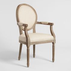 an old chair with white upholstered fabric and wood trimmings on the back