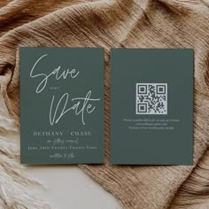 two green wedding cards with white ink on them sitting on top of a brown blanket