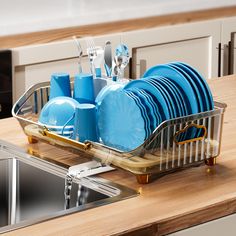 a dish rack with blue plates and silverware in it on a kitchen countertop