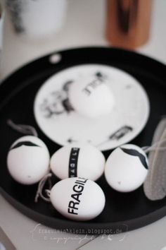 three ping pong paddles sitting on top of a black and white tray with balls