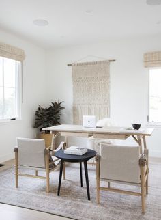 a room with two chairs, a table and a laptop on the desk in it