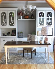 a dining room table in front of white cabinets