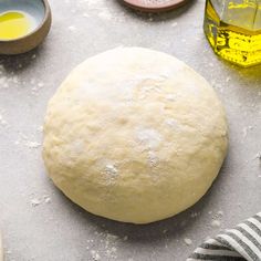 a ball of dough sitting on top of a table next to bowls and spoons