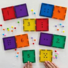 someone is playing with colored plastic blocks and numbers