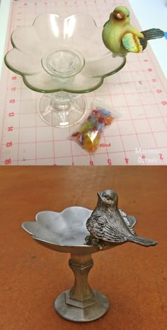 a bird figurine sitting on top of a metal bowl next to a glass dish