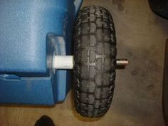 an old tire is sitting next to a blue plastic chair and other items on the floor