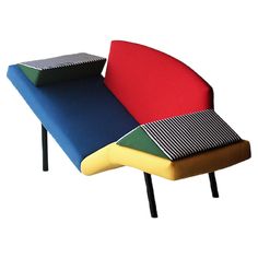 a multicolored couch with black legs and a striped seat cover on it's back