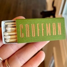 a hand holding a match box with matches in it that says,'coffman '