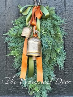 a wreath with two bells hanging from it