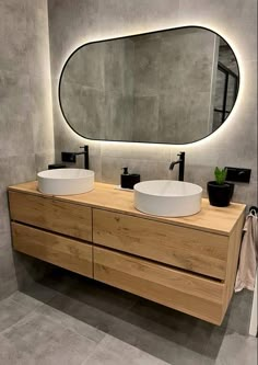 a bathroom with two sinks and a large mirror on the wall above it's counter