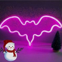 a snowman is standing in front of a neon sign with a bat on it