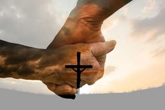 two hands holding each other with a cross in the foreground and clouds in the background