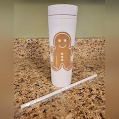 a cup with a sticker on it sitting on top of a counter next to a pen