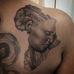 a woman's back with a tattoo on it