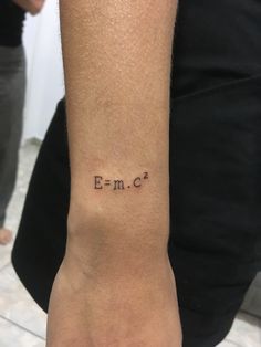 a woman's arm with the word emoc written on it and an arrow tattoo