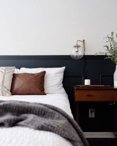 a bed with white sheets and brown pillows