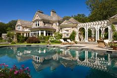 a large house with a pool in the front yard and covered patio area next to it