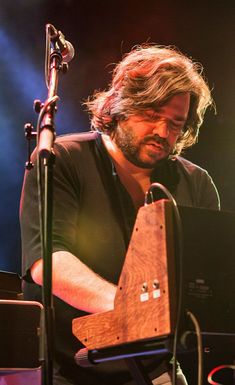 a man sitting at a keyboard in front of a microphone