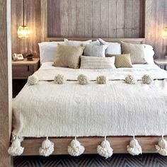 a large bed with white blankets and pillows on it's headboard in a bedroom