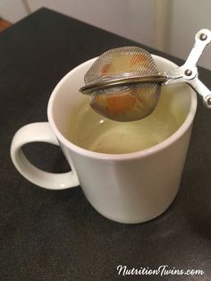 a cup filled with liquid and a tea strainer