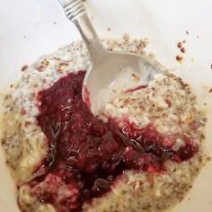 a white bowl filled with oatmeal and cranberry sauce