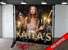 a black and gold photo booth backdrop featuring a woman holding a wine glass with fireworks in the background