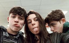 three people sticking their tongue out in front of the camera