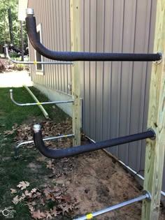 pipes are attached to the side of a building with grass and leaves on the ground