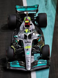 the mercedes formula car is driving down the track