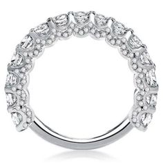 a white gold ring with rows of diamonds on the sides and an oval design in the middle