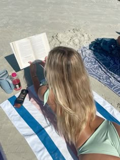 a woman reading a book on the beach