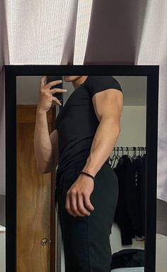 a man is standing in front of a mirror