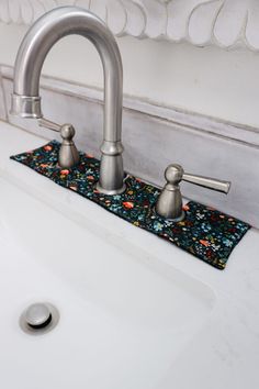 a bathroom sink with two faucets and a rug on the counter top next to it