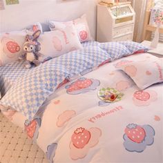 a child's bed with blue and white checkered comforter, pillows and stuffed animal